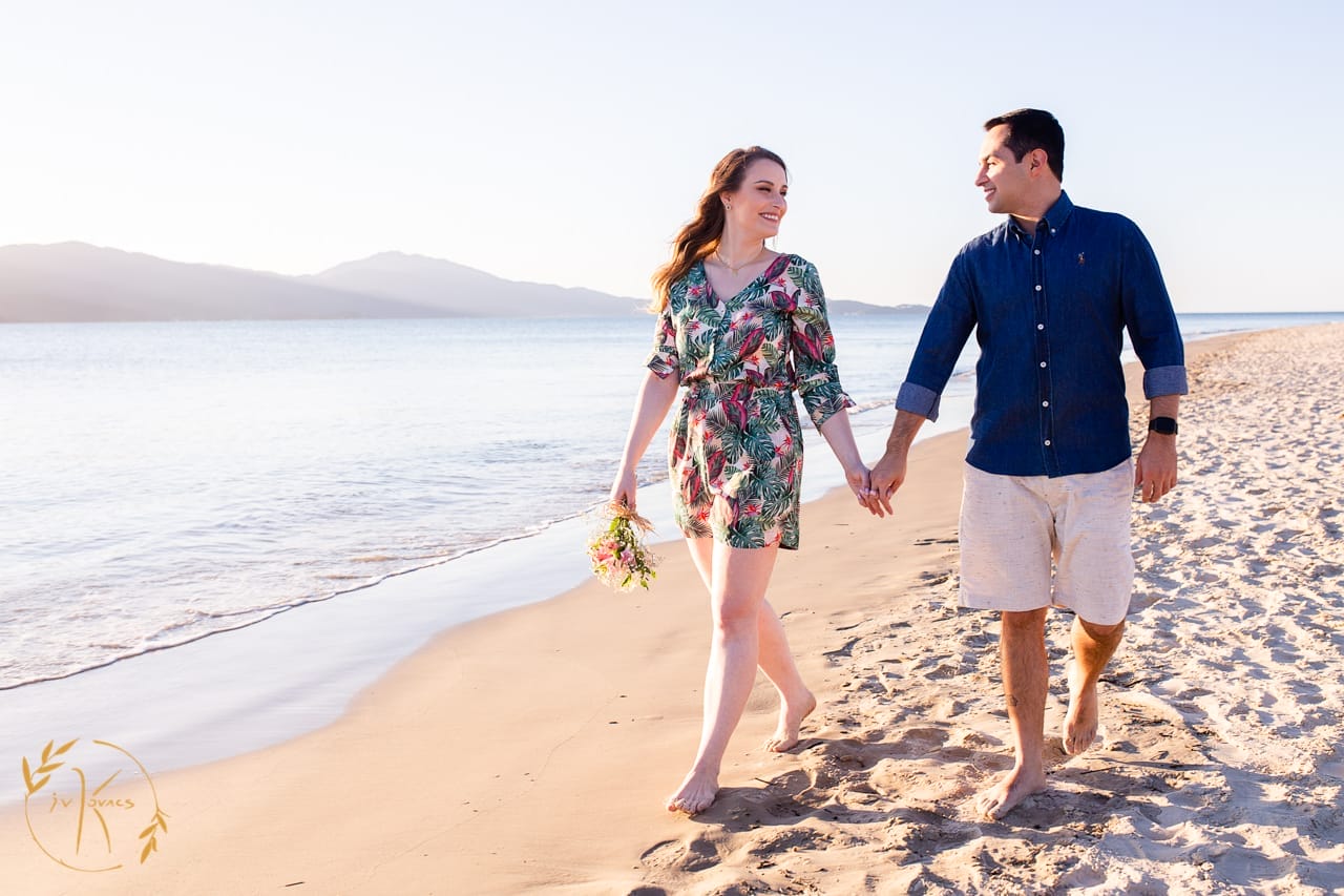 casal passeando na praia pés descalços