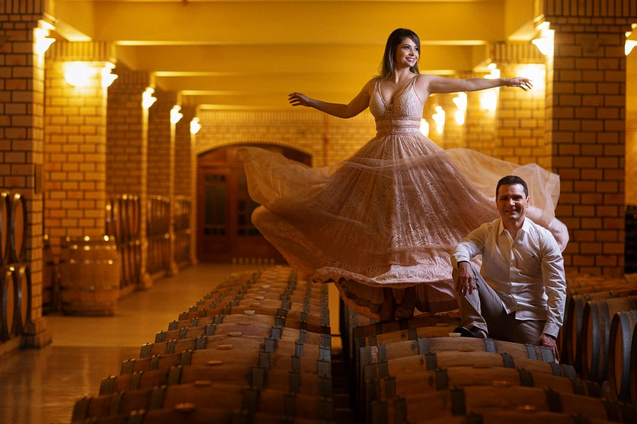 Noiva em lindo vestido sobre as barricas de vinho